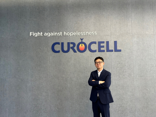 김건수 큐로셀 대표가 본사 1층에 적힌 슬로건 앞에서 포즈를 취하고 있다. 사진 이미선 기자.